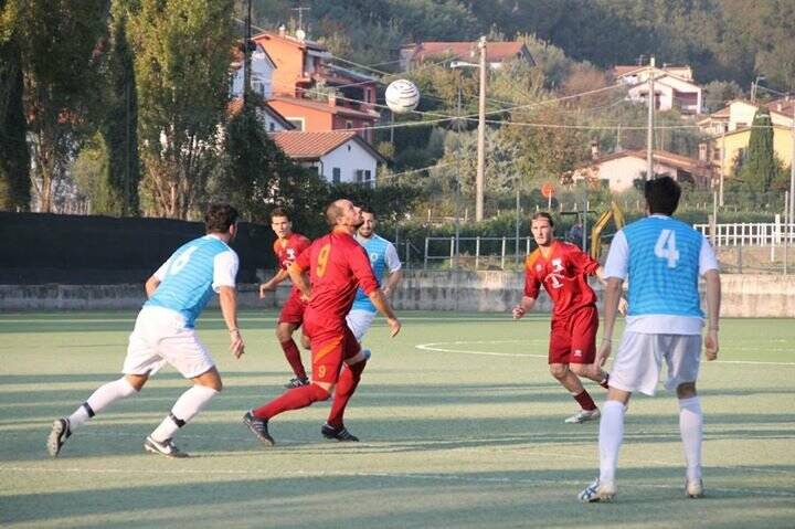 Alberti, con la maglia N°9 del Real Fiumaretta, controlla un pallone in mezzo ad una selva di difensori nella partita vinta contro il Follo San Martino.