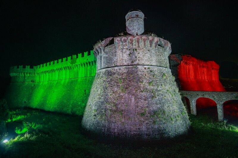 La fortezza di Sarzanello illuminata col Tricolore