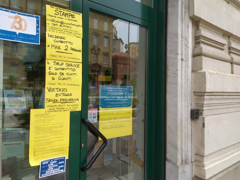 Avvertenze per i clienti all'esterno di una cartoleria di Piazza Verdi