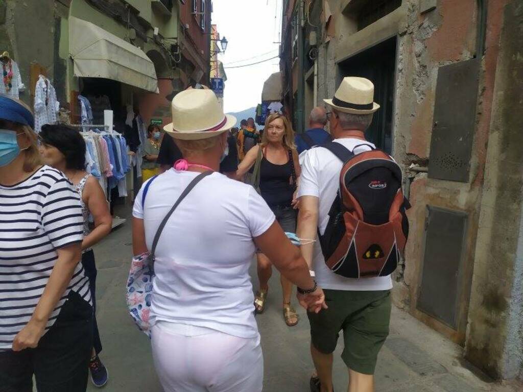 Una coppia di turisti si tiene per mano tra le vie di Vernazza
